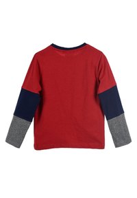 Maglietta rossa a maniche lunghe con maniche a blocchi di colore blu scuro e grigio. Materiale in cotone morbido, colletto a girocollo e orlo cucito.