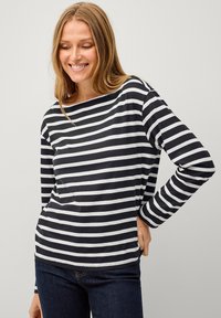 Zwart-wit gestreepte lange mouwen top met een bootnek, gemaakt van zachte stof. De top heeft een relaxed fit en een rechte zoom.