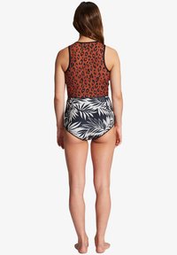 Multikleurige zwempak met een bovenstuk met luipaardprint in bruin en zwart, en een onderstuk met een zwart-wit palmbladerenpatroon. Hooggestelde pasvorm.