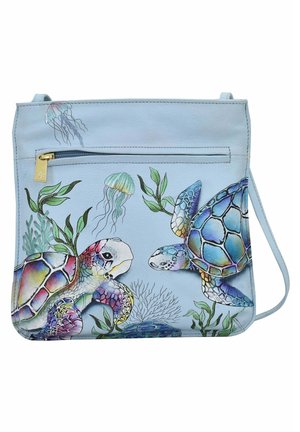Light blue crossbody bag with turtle and jellyfish illustrations, featuring a top zipper closure and adjustable strap. Smooth texture, vibrant colors.