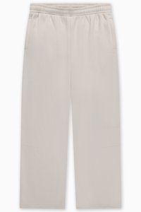 Ανοιχτό μπεζ φόρμα με ελαστική μέση, δύο πλαϊνές τσέπες και διακριτικές ραφές στα πόδια. Λεία υφή υφάσματος.