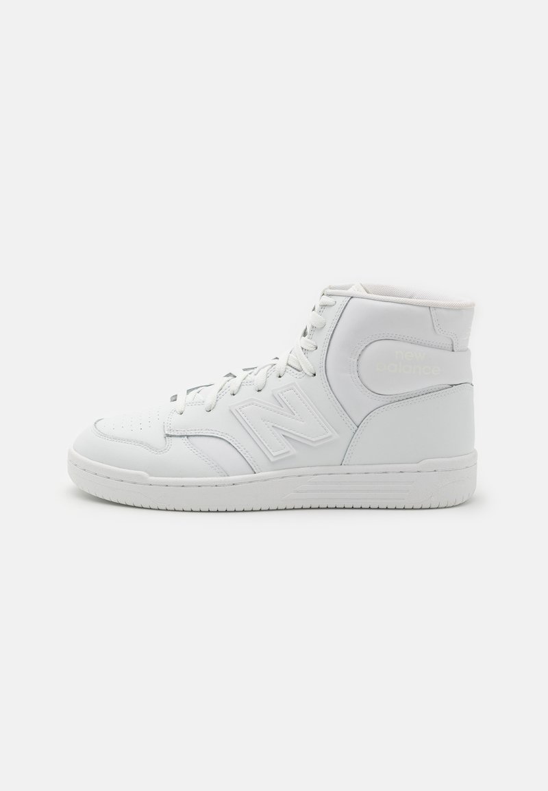 Baskets blanches montantes avec lacets, semelle texturée et logo "N" sur le côté, vues de profil sur fond uni.