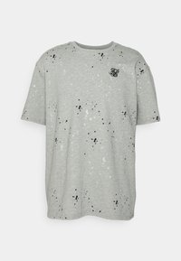 Grå T-shirt i bomull med avslappnad passform. Har ett stänkmönster i svart och vitt, samt en liten logotyp på bröstet.
