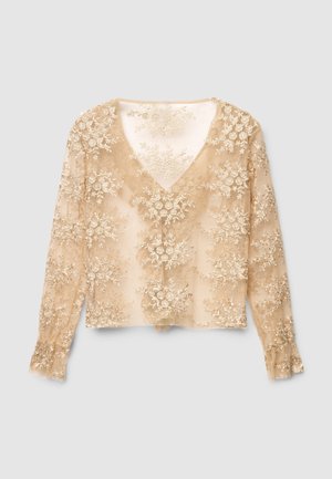 Top beige a maniche lunghe con scollo a V, caratterizzato da un ricamo floreale intricato in filo dorato e tessuto trasparente testurizzato. Polsini svasati.