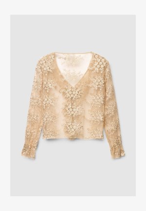 Top beige a maniche lunghe con scollo a V, caratterizzato da un ricamo floreale intricato in filo dorato e tessuto trasparente testurizzato. Polsini svasati.