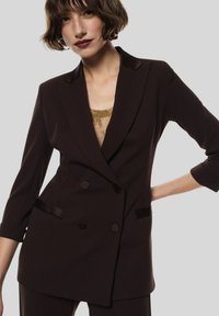 Blazer marrone doppiopetto con dettagli in satin, colletto a intaglio e due tasche frontali. Tessuto liscio con vestibilità su misura.