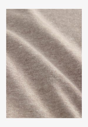 Beige textured fabric with a soft, ribbed knit; features a subtle pattern, slightly varying tones, and smooth surface.