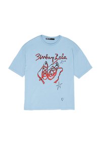 Camiseta de manga corta azul claro con ilustración de zapatillas de ballet rojas, texto "Bimba y Lola", una estrella y un gráfico de pequeño corazón en la parte delantera.