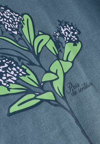 Tekstil med en mørkeblå baggrund og et grønt blomstermønster. Tekst "Pois de senteur" i kursiv nær planten. Glat tekstur.