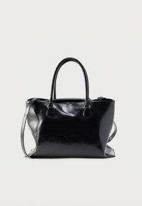 Μαύρη δερμάτινη τσάντα χειρός με διπλές λαβές και ρυθμιζόμενο ιμάντα ώμου σε απλό φωτεινό φόντο.