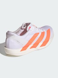 Biela športová obuv s oranžovými pruhmi, textilným zvrškom, ľahkým dizajnom, polstrovaným golierom a textúrovanou podrážkou. Má značkové detaily.