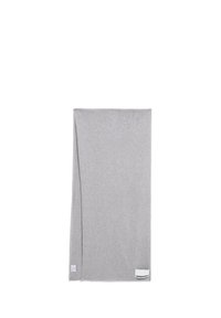 Couverture grise, rectangulaire, fabriquée en tissu doux. Présente un coin replié et une petite étiquette avec le nom de la marque sur un bord.