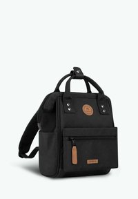 Schwarzer Stoffrucksack mit kurzen Tragegriffen, verstellbarem Schulterriemen, vorderer Reißverschlusstasche und einer Logo-Applikation sowie Akzenten aus hellbraunem Leder. Robuste Verarbeitung.