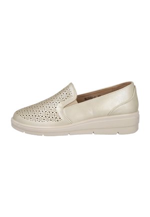 Zapato beige tipo slip-on con patrón floral perforado en la parte superior, inserciones laterales elásticas y una suela gruesa y acolchada para mayor comodidad.
