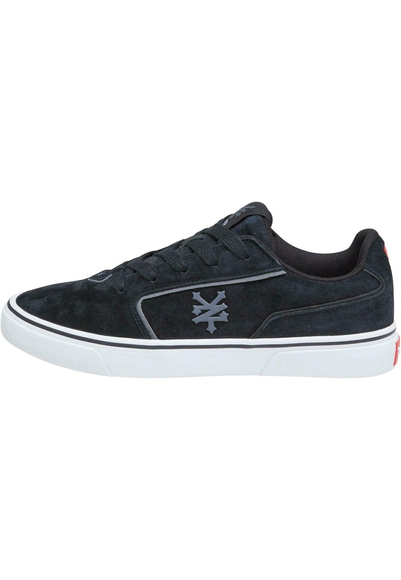 Fekete nubuk sneaker fehér gumitalppal és szürke logóval. Jellemzője az alacsony szabás, kerek orr és fekete textil bélés.