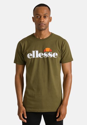 T-shirt en coton vert olive avec un col rond. Présente un grand logo blanc "ellesse" avec un demi-cercle orange et rouge au-dessus.