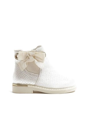 Stivale alla caviglia bianco con trama in rilievo, motivo trapuntato, fiocco in tessuto come dettaglio, elementi dorati e suola sottile. Presenta un pannello elastico laterale.