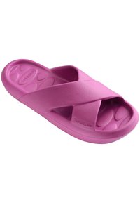 Pink cross-strap slide sandal made of soft material. Features a textured footbed and a rounded sole for comfort.