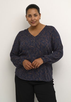 Blusa de manga larga azul marino con escote en V, que presenta un estampado de paisley en marrón claro. Tejido suave con puños elásticos y corte relajado.
