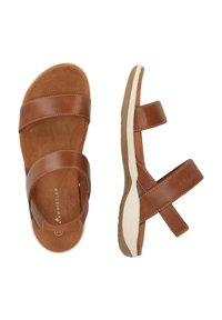 Sandales en cuir marron avec deux larges brides et un design à brides croisées, présentant une semelle intérieure beige et une semelle en caoutchouc blanche. Style décontracté et plat.