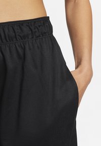 Svarta sportshorts i texturerat tyg med elastisk midjeband och sidoficka, med en avslappnad passform och andningsförmåga.