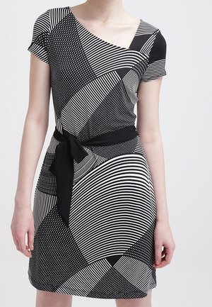 Robe à motifs noir et blanc avec des manches courtes, décolleté asymétrique, ceinture à la taille, présentant des rayures, des points et diverses formes géométriques.