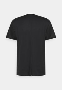 Svart t-shirt med kort ärm och synlig mittsöm på baksidan, uppvisad mot en enkel vit bakgrund.