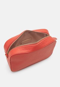 Coccinelle TEBE - Soma ar siksnu pāri ķermenim - grenadine red