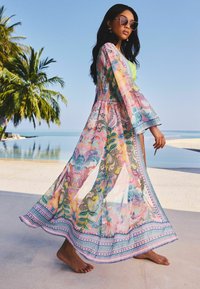Sheer, floral kimono-style robe in pastel colors with long sleeves and patterned border; lightweight fabric flows gracefully.