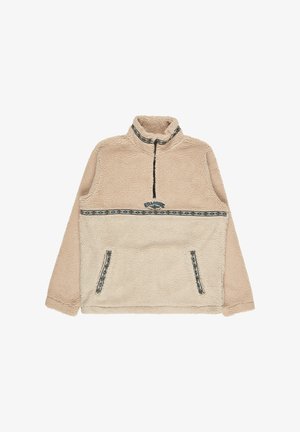 Beige fleece trøje med halvlukket krave, der har et mønstret bånd hen over brystet og to forlommer med lignende detaljer.
