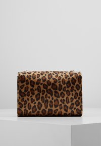 Leopardikuvioitu käsilaukku, jossa on karvamaisen tekstuurin kaltainen materiaali, suorakaiteen muoto ja kultaisen sävyn metallikoristeet yläreunassa.