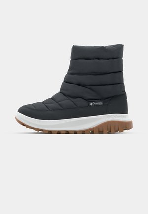 Black insulated ankle boot with quilted design, rubber sole, and white midsole. Features logo detail on outer side and textured tread.