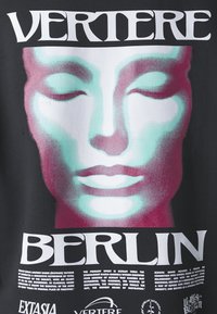 Vestimenta preta com um design gráfico de um rosto sereno em tons de turquesa e rosa, com texto em branco em destaque a dizer "VERTERE BERLIN" acima.