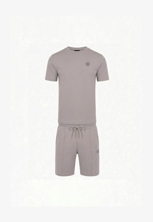 Rövid szürke alkalmi szett egyszínű pólóval és zsinóros rövidnadrággal, kis, egyező logókkal a mellkason és a bal combon.