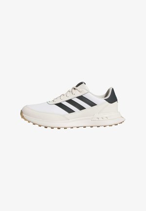 Scarpe da ginnastica bianche con strisce nere, dotate di una suola in gomma testurizzata, parte superiore in pelle liscia e colletto imbottito per supporto.