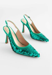 Zaļas sequined slingback kurpes ar smailu purngalu, teksturētu virsu un plānu, bēšu stiletto papēdi. Iekļauj regulējamu siksnu.