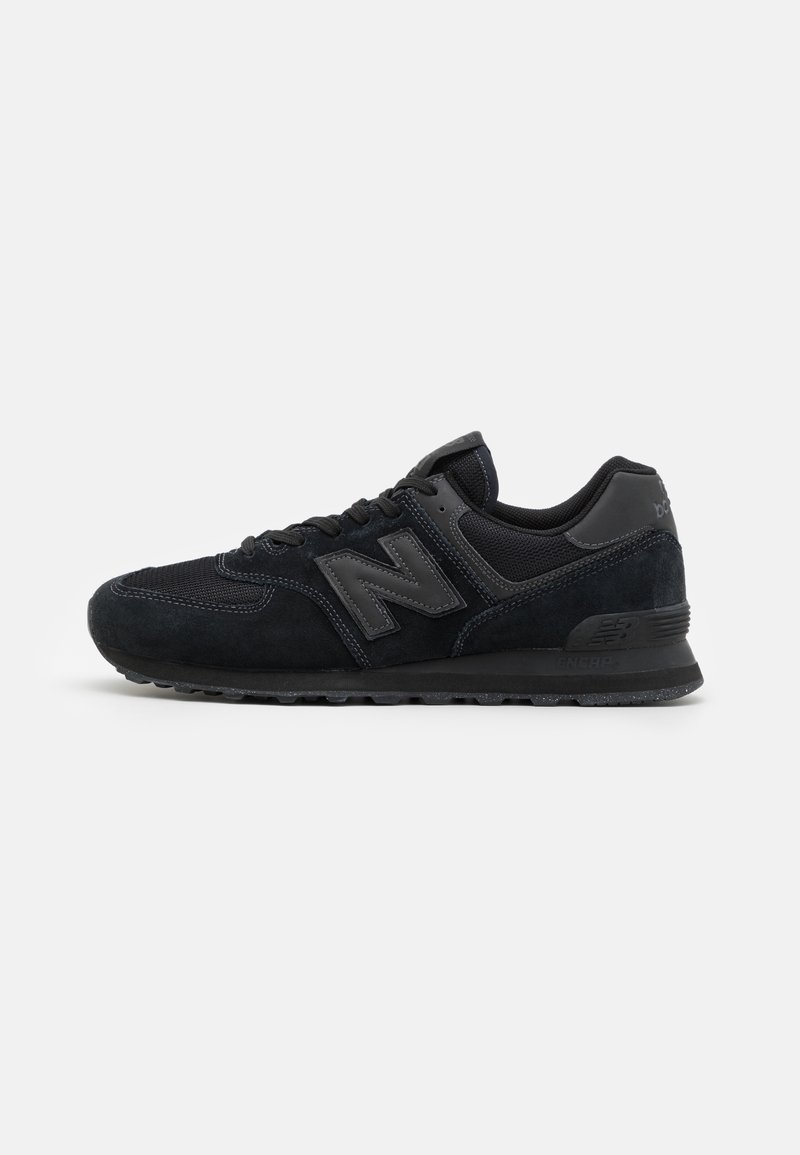 Baskets noires New Balance avec une tige en suède et mesh, fermeture à lacets et logo "N" marqué sur le côté, vues de l’extérieur.