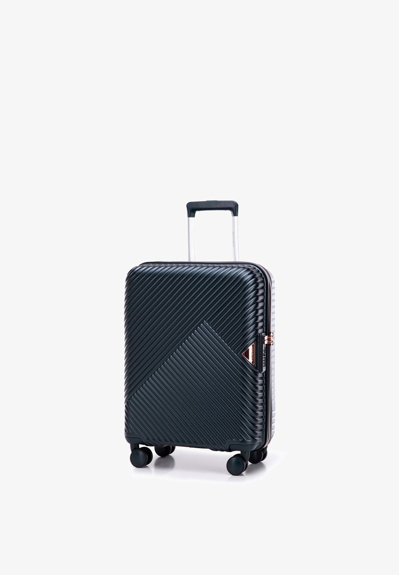 Valise cabine rigide noire avec des rainures diagonales, poignée rétractable, quatre roues et serrure à glissière latérale.