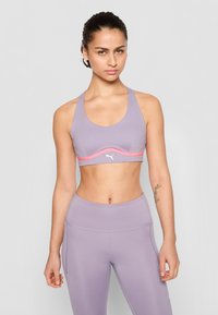Soutien-gorge de sport violet clair avec une bande d'accent rose, fabriqué dans un matériau lisse et extensible. Pantalons de yoga taille haute assortis en violet clair.