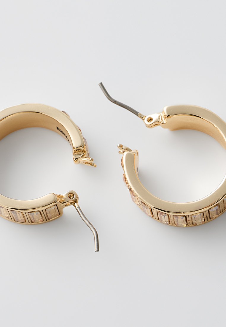 Goldene Creolen mit einer glatten Oberfläche und rechteckig geschliffenen Steinen als Akzent. Der Scharnierverschluss lässt sich drehen, um ein einfaches Tragen zu ermöglichen.