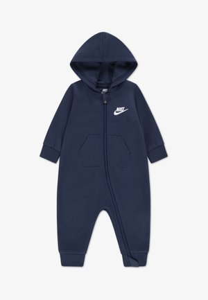 Tuta con cappuccio blu navy realizzata in tessuto morbido, dotata di zip frontale, tasche a marsupio e logo Nike bianco sul petto.