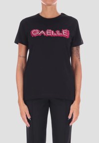 T-shirt in cotone nero con un logo in perline rosa e bianco "GAELLE" in rilievo sul davanti. Collo rotondo classico e maniche corte.