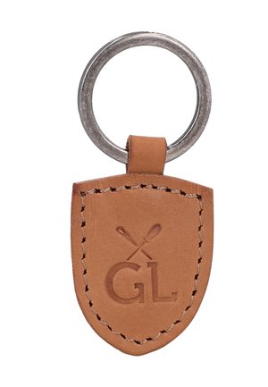 Brauner Leder-Schlüsselanhänger in Schildform, mit genähten Kanten, geprägten gekreuzten Polomallets und den Buchstaben GL unter den Mallets.