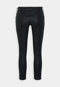 Svarta skinny jeans med en slät, något glansig yta, som har två bakfickor och en figurnära design som blir smalare vid ankeln.