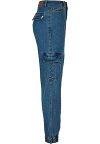 Pantalon cargo en denim bleu avec poignets élastiques, poche à rabat latérale, poche arrière, passants de ceinture et coutures apparentes.