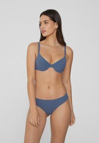 Modrý bikini set s hladkým povrchem, tenkými nastavitelnými ramínky a minimalistickým designem s decentním střihem kalhotek.