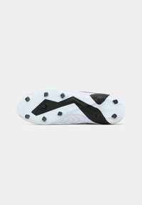 Soccer cleat sole in white and black, featuring a textured surface, angular design, and six prominent studs for traction.
