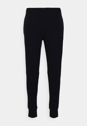 Zwarte slim-fit joggingsbroek met elastische tailleband en omgeslagen enkels op een egale lichte achtergrond.