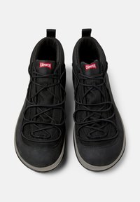 Scarpe nere alte con dettagli in rete e lacci elastici, con il logo CAMPER rosso sulla linguetta.