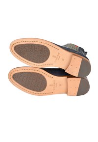 Skórzane podeszwy butów w kolorze granatowym z jasnobrązowymi akcentami z gumy, z wzorzystą wkładką z wytłoczonym napisem "CRICKIT", rozmiar 37.